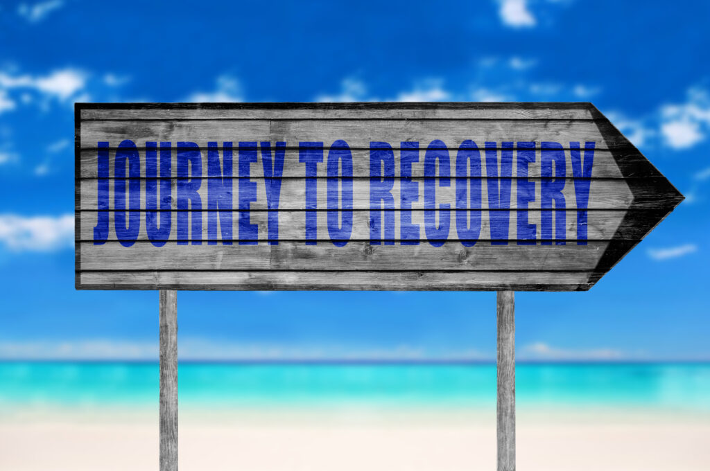 Journey to Recovery wooden sign with on a beach background