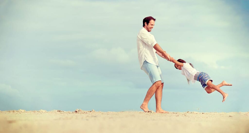 Dad Swinging Daughter on the Beach